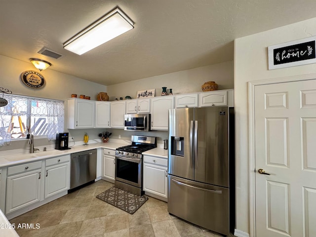 kitchen featuring stainless steel appliances, a sink, and white cabinets