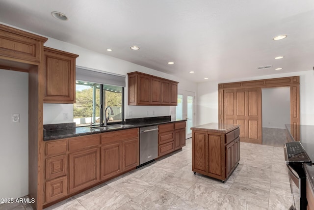 kitchen featuring sink, a kitchen island, stainless steel dishwasher, and plenty of natural light