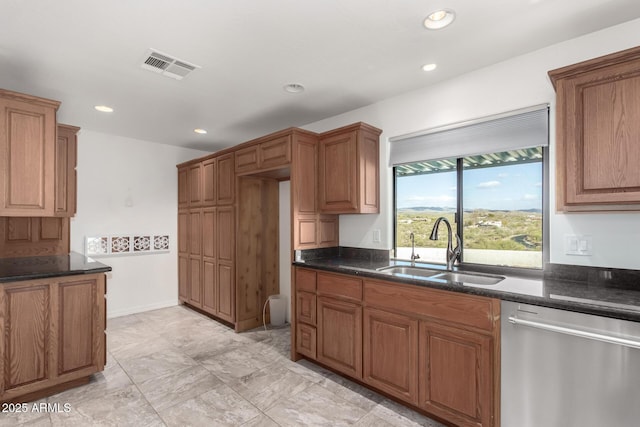 kitchen with dishwasher, sink, and dark stone counters