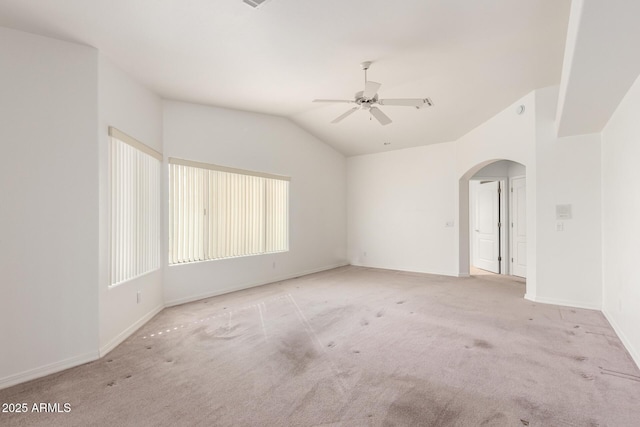 carpeted empty room with vaulted ceiling and ceiling fan