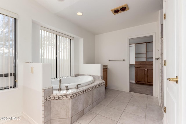 bathroom with tile patterned flooring and tiled bath