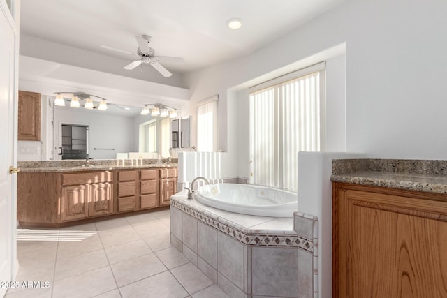 bathroom featuring tile patterned floors, tiled tub, ceiling fan, and vanity