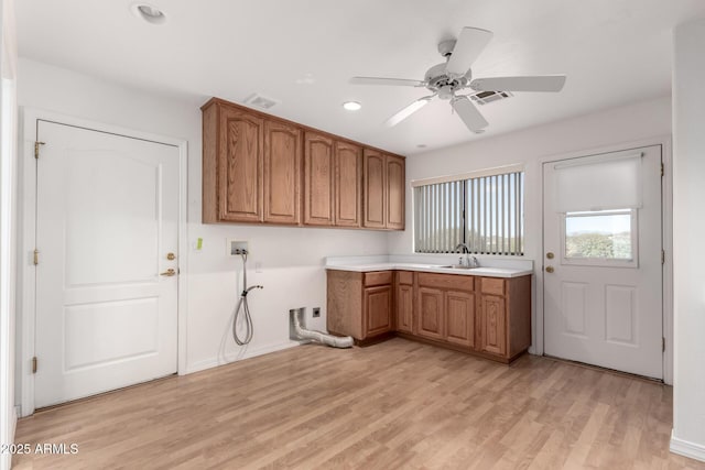 laundry room with ceiling fan, sink, cabinets, light hardwood / wood-style flooring, and hookup for a washing machine