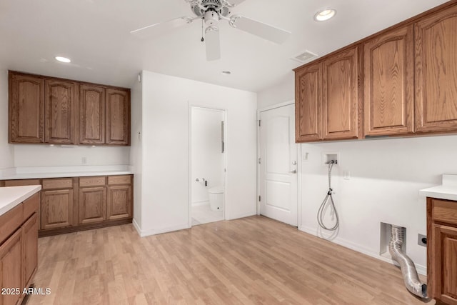 washroom with cabinets, hookup for a washing machine, light hardwood / wood-style flooring, and ceiling fan