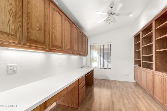 kitchen with built in desk, light hardwood / wood-style floors, ceiling fan, and lofted ceiling