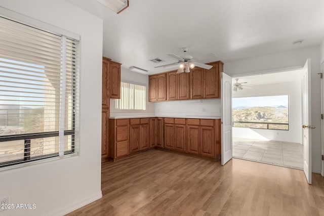 kitchen featuring ceiling fan, a healthy amount of sunlight, and light hardwood / wood-style flooring