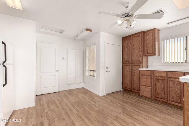 kitchen with ceiling fan, white refrigerator, and light hardwood / wood-style flooring