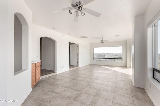 unfurnished living room with light tile patterned floors and ceiling fan