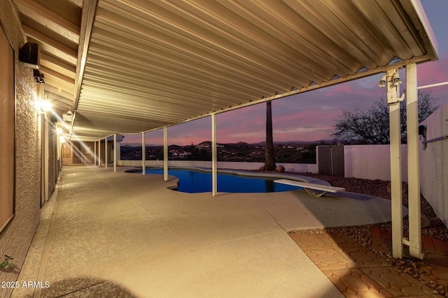 pool at dusk with a patio