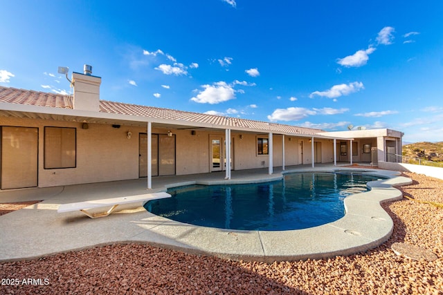 view of swimming pool with a diving board and a patio area