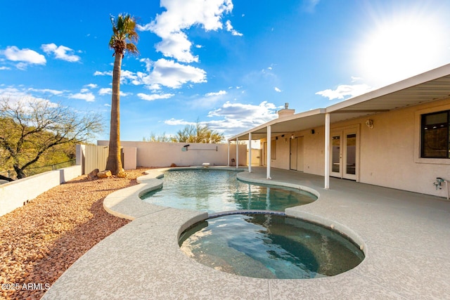 view of swimming pool featuring a patio area, an in ground hot tub, and french doors