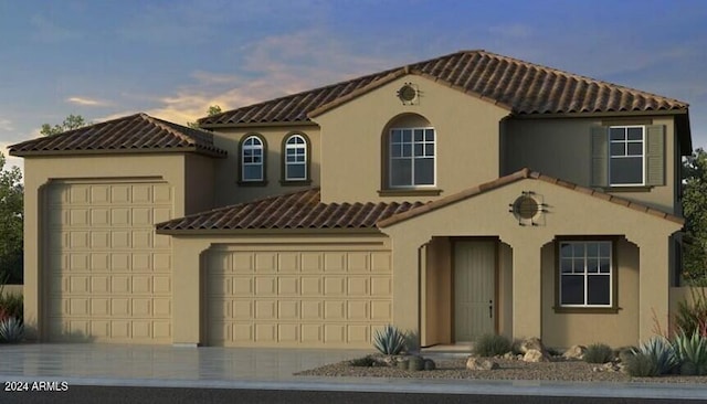 mediterranean / spanish house featuring a garage, a tiled roof, concrete driveway, and stucco siding