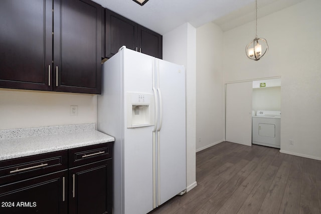 kitchen featuring an inviting chandelier, white refrigerator with ice dispenser, wood-type flooring, decorative light fixtures, and washer / dryer