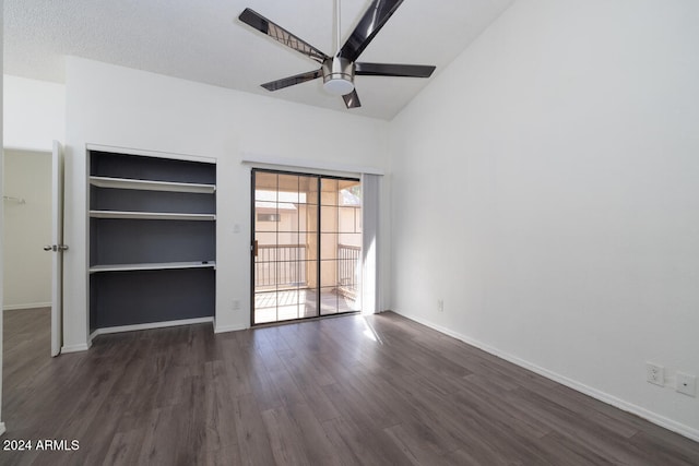 interior space with vaulted ceiling, ceiling fan, built in shelves, a textured ceiling, and dark hardwood / wood-style flooring