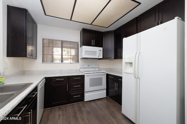 kitchen featuring white appliances, dark hardwood / wood-style floors, dark brown cabinetry, and sink