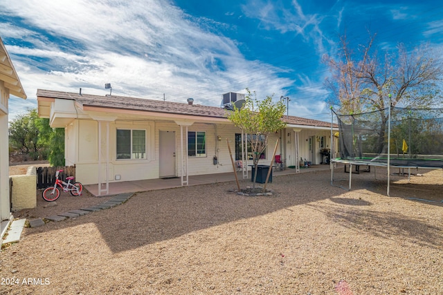 rear view of property featuring a patio and a trampoline