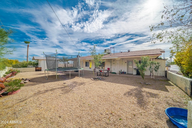 back of property featuring a trampoline