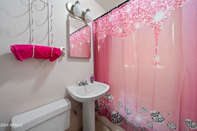 bathroom with a shower with shower curtain and toilet