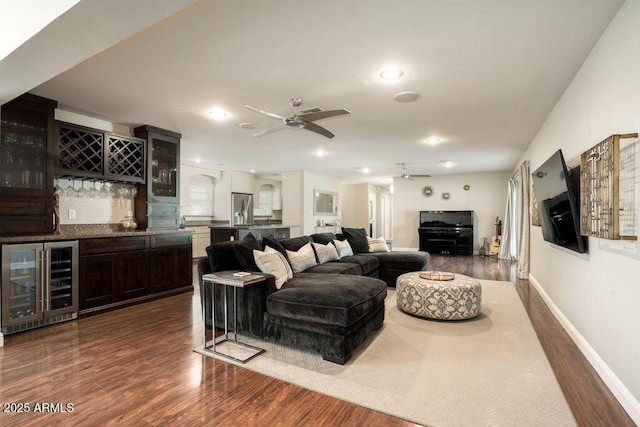 living room with bar, ceiling fan, beverage cooler, and dark hardwood / wood-style floors