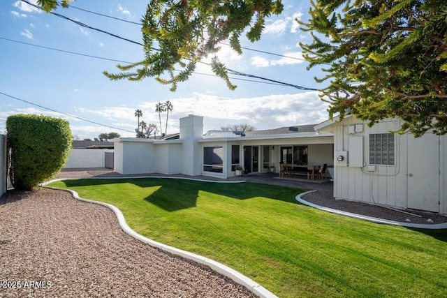 back of property with a lawn and a patio area