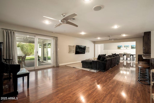 living room featuring ceiling fan and dark hardwood / wood-style floors