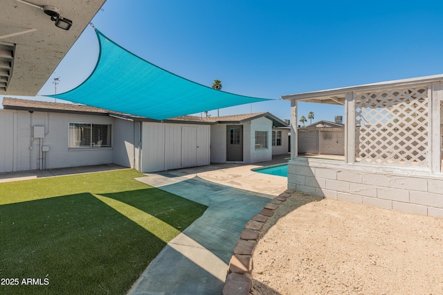 back of property featuring an outdoor pool, a patio, and a yard