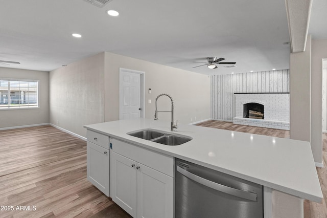 kitchen featuring white cabinets, dishwasher, a ceiling fan, a sink, and open floor plan