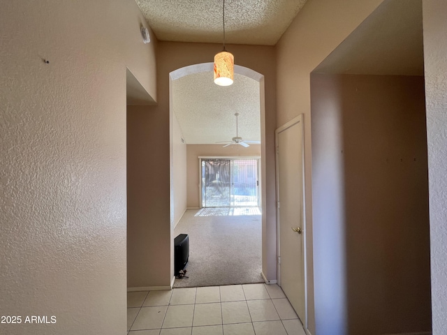 1871 E Westchester Dr, Chandler, AZ 85249 - hallway with a textured ceiling, arched walkways, light tile patterned floors, baseboards, and a textured wall