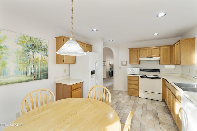 kitchen featuring pendant lighting, white appliances, sink, and light hardwood / wood-style flooring