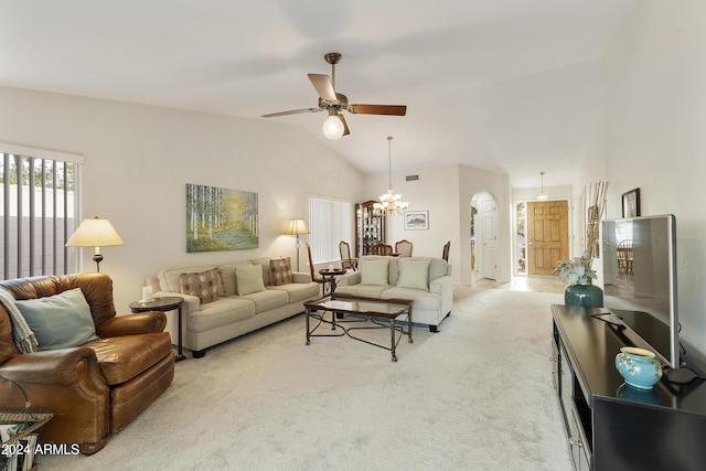 carpeted living room with ceiling fan with notable chandelier and vaulted ceiling