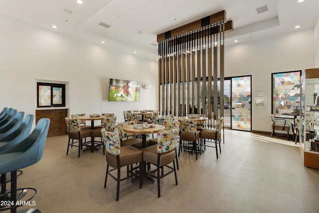 dining area featuring a tray ceiling and a high ceiling