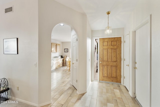 entryway featuring light hardwood / wood-style flooring and a notable chandelier