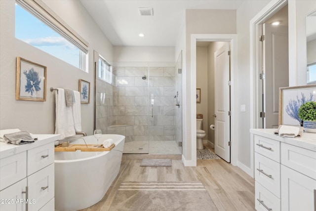 8396 E Granite Pass Rd, Scottsdale, AZ 85266 - bathroom featuring wood finished floors, a stall shower, a freestanding bath, vanity, and toilet