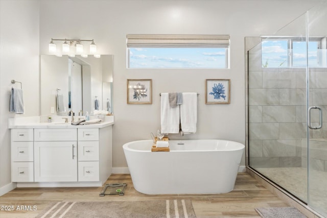 8396 E Granite Pass Rd, Scottsdale, AZ 85266 - bathroom with wood finished floors, a freestanding bath, a stall shower, vanity, and plenty of natural light