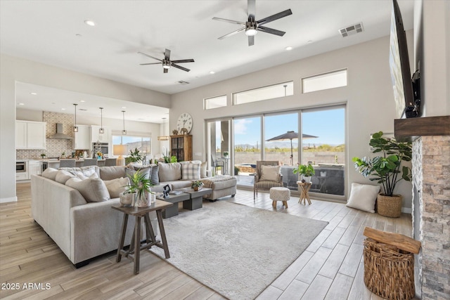 8396 E Granite Pass Rd, Scottsdale, AZ 85266 - living room with a ceiling fan, light wood finished floors, recessed lighting, and a towering ceiling
