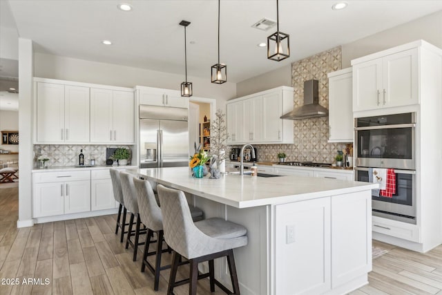8396 E Granite Pass Rd, Scottsdale, AZ 85266 - kitchen featuring wall chimney range hood, appliances with stainless steel finishes, tasteful backsplash, a sink, and white cabinets