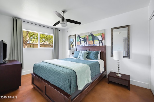 bedroom with baseboards, a ceiling fan, and concrete floors