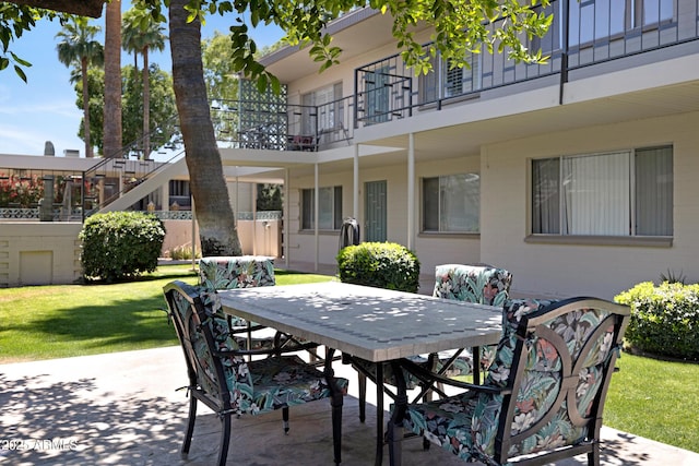 view of patio featuring outdoor dining space and a balcony