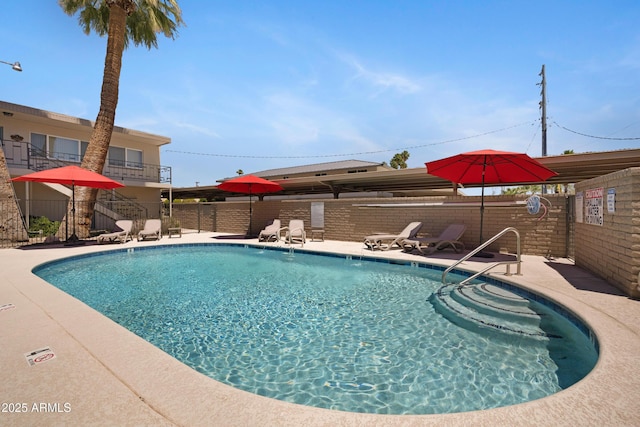 community pool with fence and a patio area