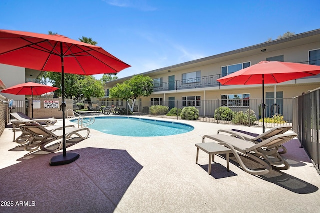 community pool featuring fence and a patio area
