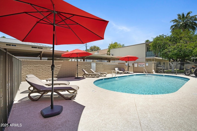 community pool featuring a patio area and fence