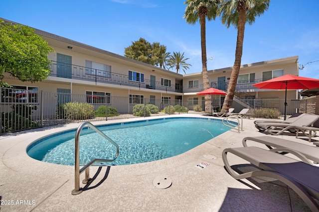 community pool featuring fence and a patio area