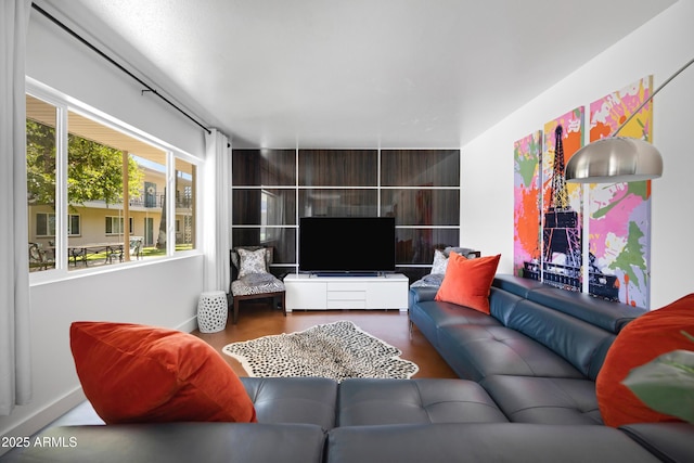living area with baseboards and wood finished floors