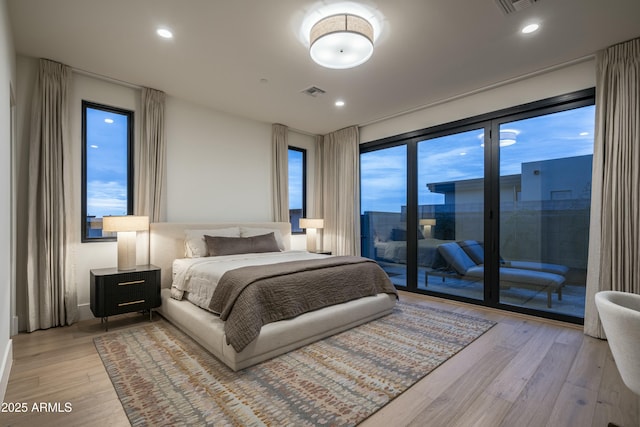 bedroom with access to outside and light wood-type flooring