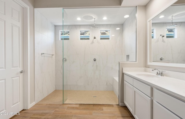 bathroom with a tile shower and vanity