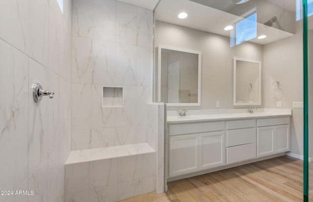 bathroom with vanity, wood-type flooring, and tiled shower