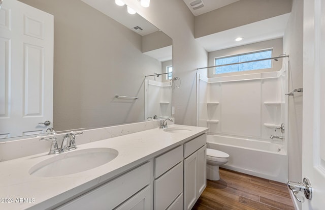 full bathroom featuring vanity, wood-type flooring, shower / bathtub combination, and toilet