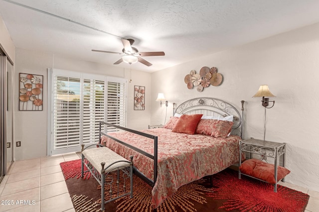 tiled bedroom featuring ceiling fan and a textured ceiling