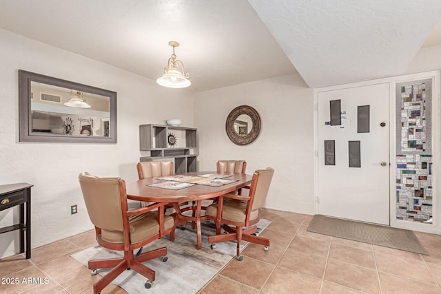 dining area featuring a textured ceiling and light tile patterned flooring