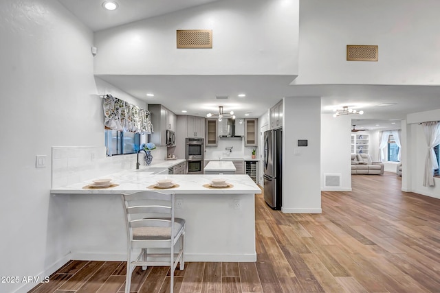 35005 N Central Ave, Phoenix, AZ 85086 - kitchen featuring stainless steel appliances, a peninsula, a chandelier, light wood-style flooring, and glass insert cabinets